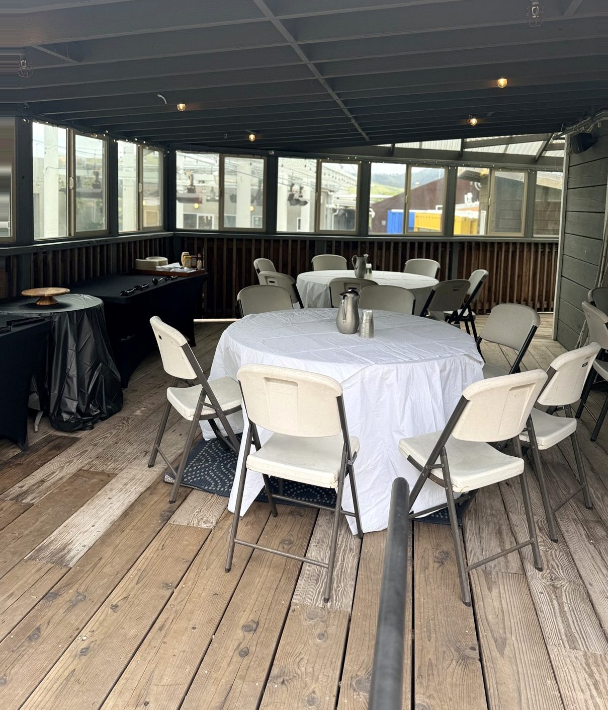 The covered event room set with round banquet tables and white linens