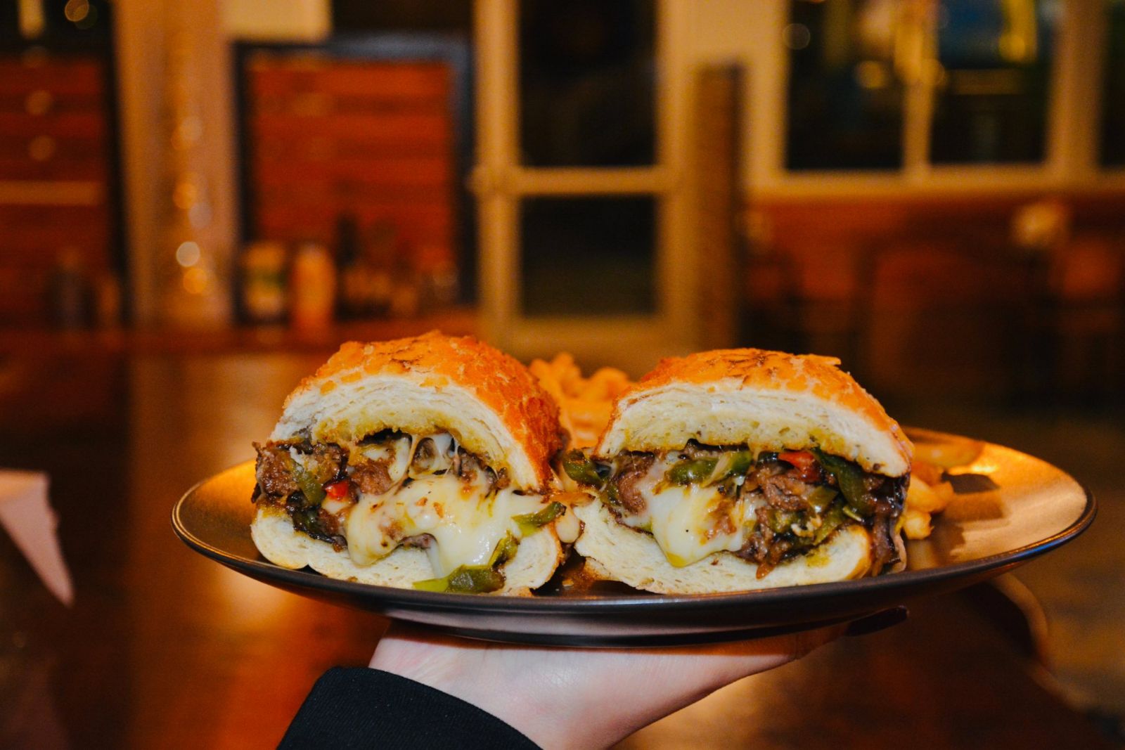 Philly cheesesteak on Dutch crunch with melted cheese and peppers